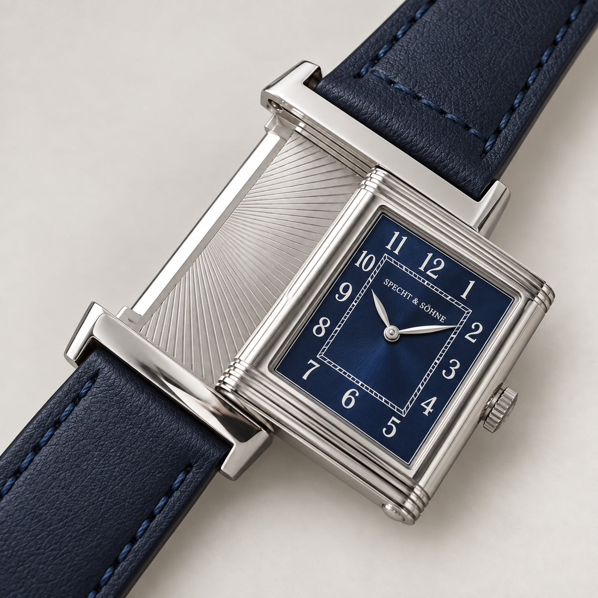 Specht & Söhne Reverso Ultrafino 24mm com caixa reversível aberta, mostrador azul-marinho com numerais arábicos e pulseira de couro azul.